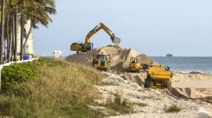 Workers place sand at Midtown Beach. ( Credit: Palm Beach Daily News)