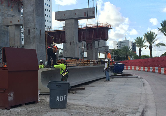 Construction workers prepare to hoist the first of 247 concrete beams for Brightline's track at MiamiCentral
