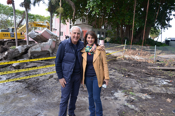 Christian de Berdouare and his wife Jennifer Valoppi pose in front of the property that was the Miami Beach home of deceased Colombian drug lord Pablo Escobar during its demolition in January 2016. (Credit: Getty Images)