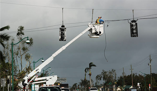 An electrician works to fix a traffic light during the power outage caused by Hurricane Irma (Credit: Getty)