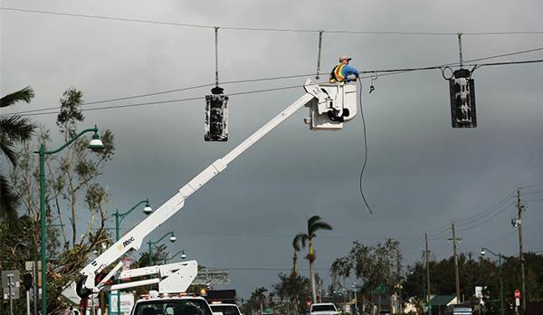 An electrician works to fix a traffic light during the ongoing power outage caused by Hurricane Irma (Credit: Getty)