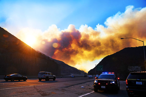 Smoke from the Skirball Fire rises above the 405 freeway near the Bel Air area of Los Angeles, California, December 6, 2017. (Credit: ROBYN BECK/AFP/Getty Images)