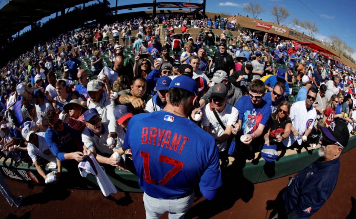 Chicago Cubs third baseman Kris Bryant signs autographs before a spring baseball game (Credit: AP Photo/Chris Carlson)