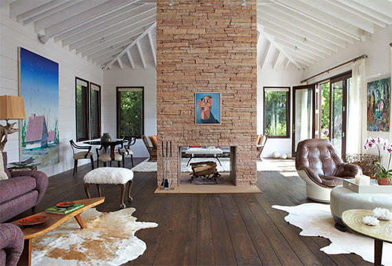 A fireplace is the centerpiece of the home's expansive living room, with its myriad textures and walls of tongue-and-groove, white-painted pine (Photo: Peter Murdock)