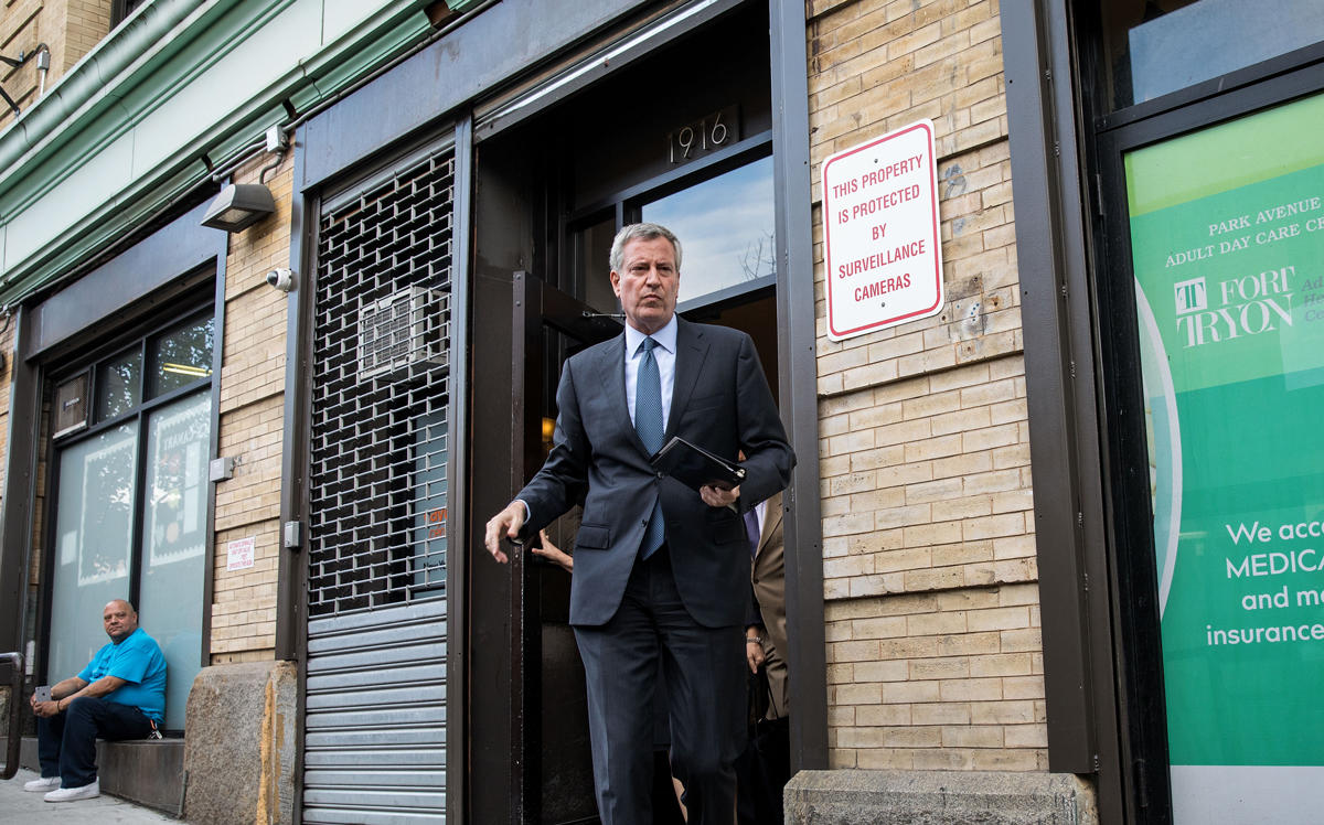 Mayor Bill de Blasio walking out of an apartment (Credit: Getty Images)