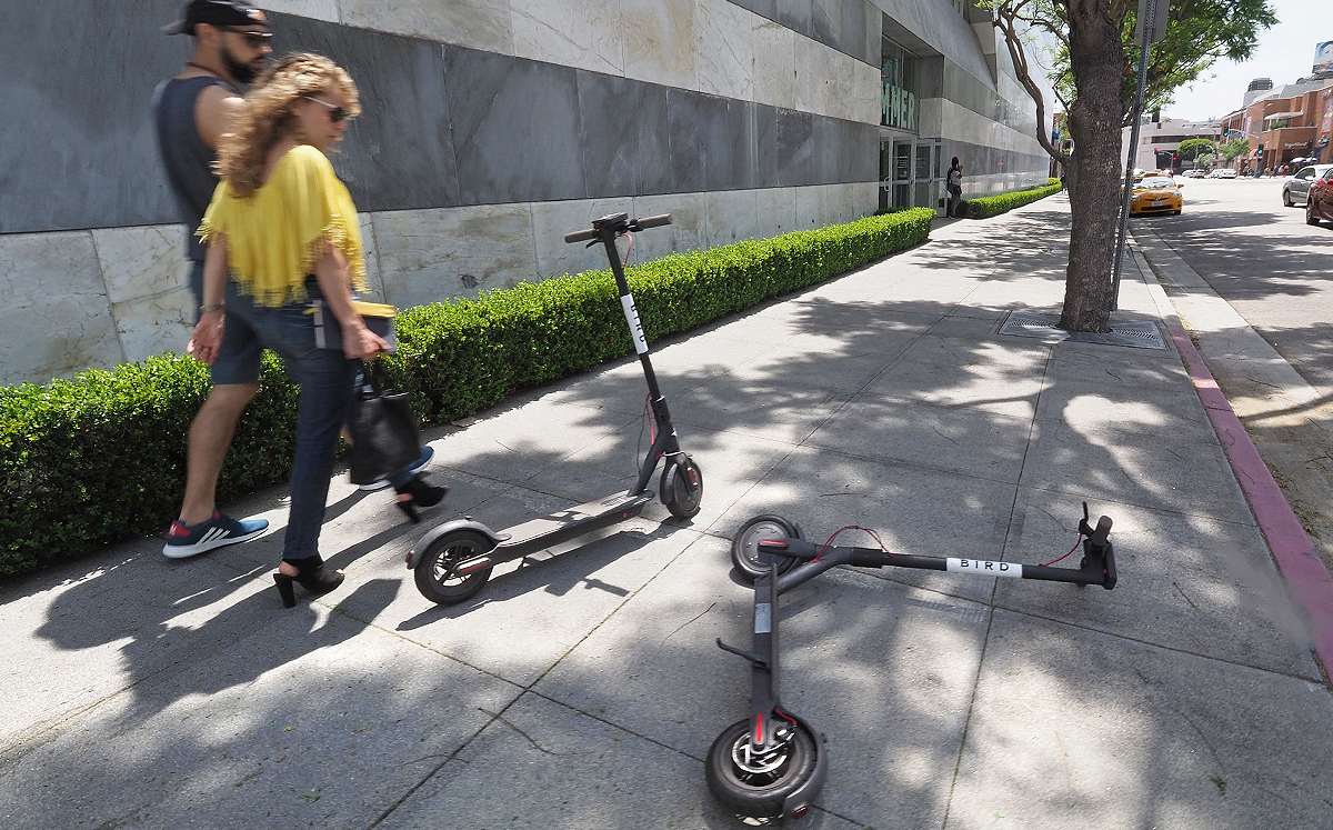 Two Bird scooters laying in the middle of a sidewalk in Los Angeles (Credit: Getty Images)