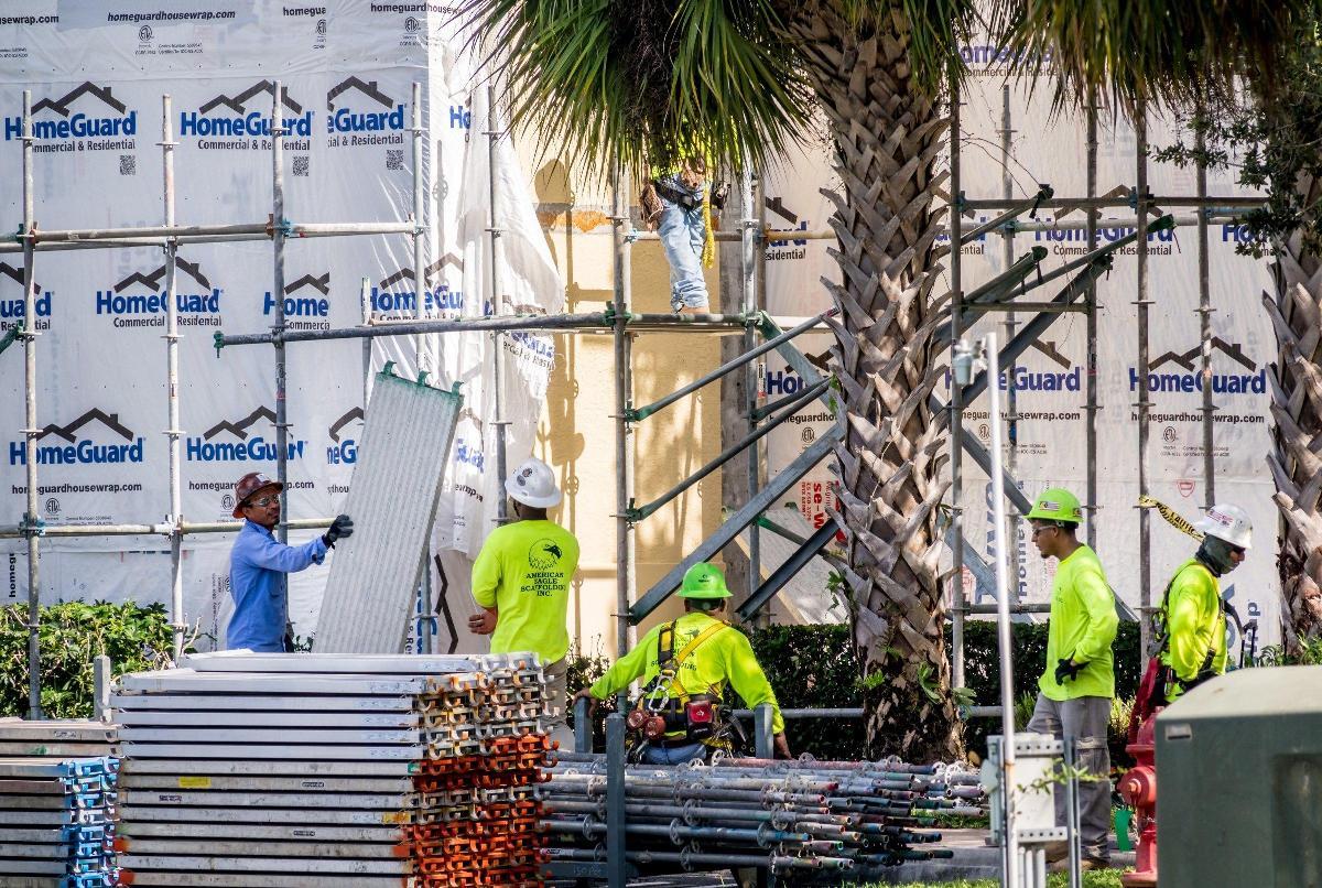 Workers remove scaffolding after San Matera condo repair work stopped in April. (Credit: Richard Graulich | Palm Beach Post)