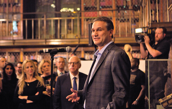 Andy Todd speaking at an event as Douglas Elliman Chairman Howard Lorber looks on