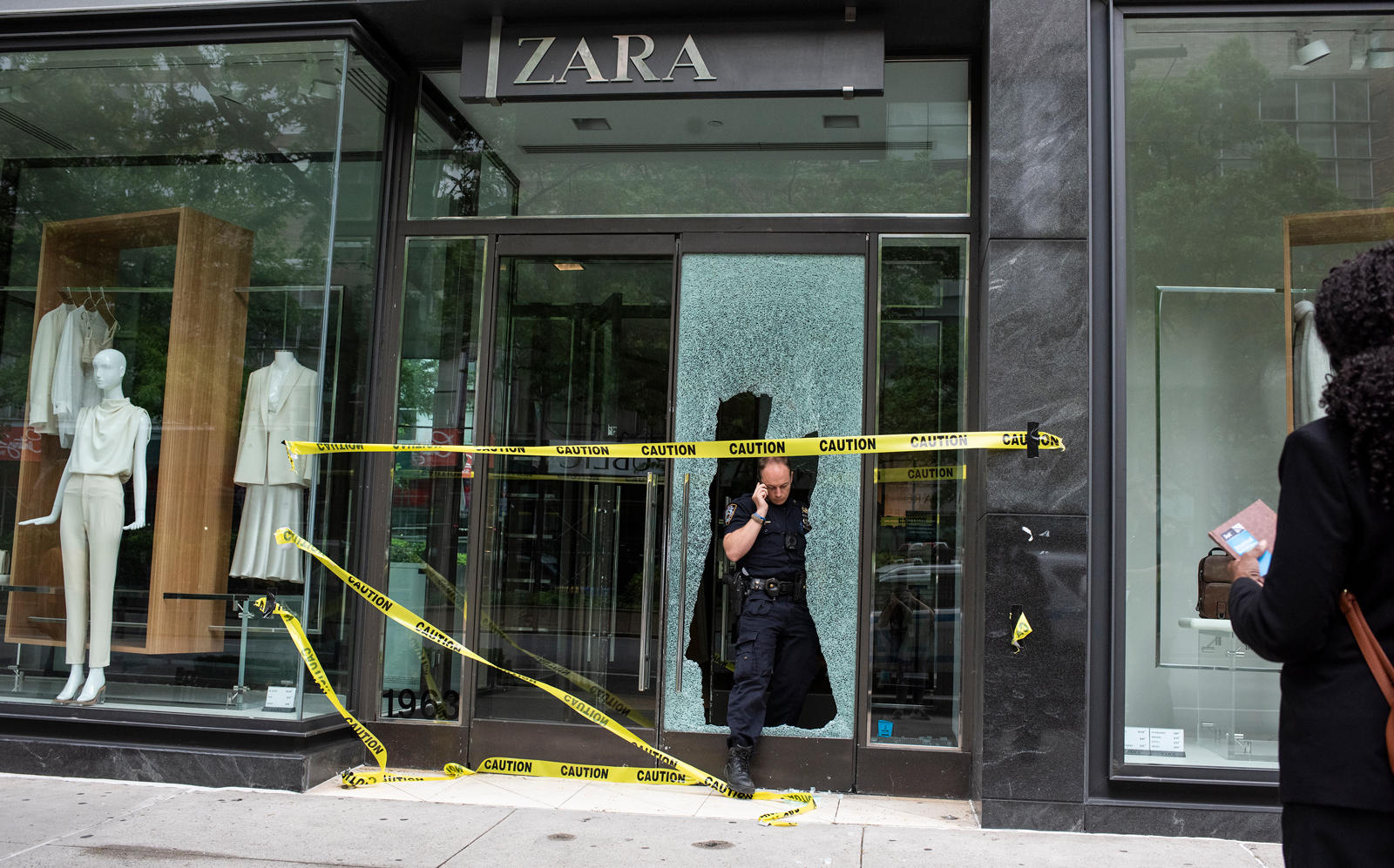 A Police officer leaves from a Zara store after a night of looting (Getty)