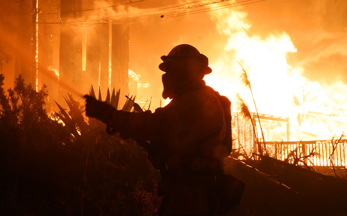 Firefighters work to protect homes surrounding residences engulfed in flames. CZU Lightning Complex fires. (Credit: Dylan Bouscher/MediaNews Group/The Mercury News via Getty Images)