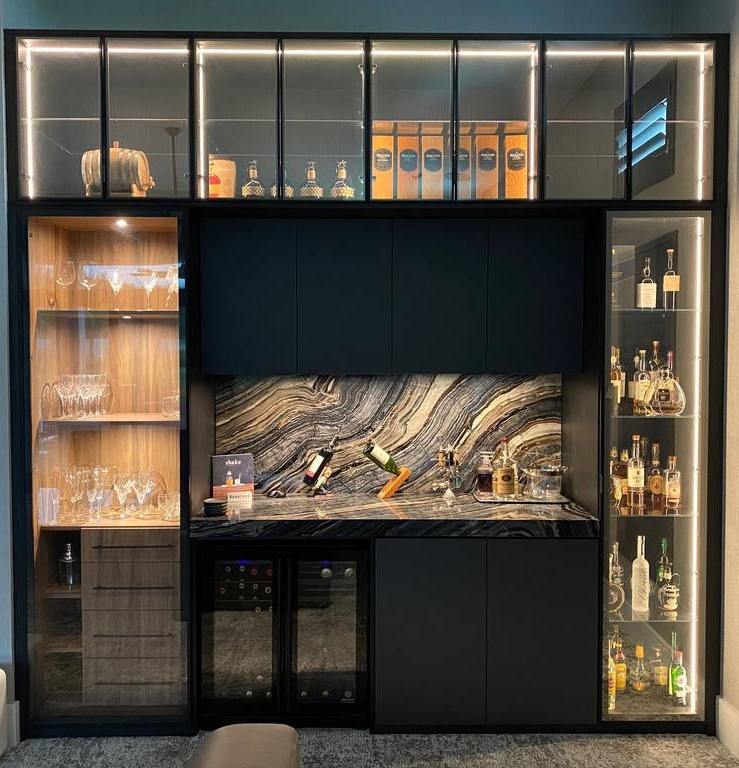 This gorgeous custom designed bar uses the mix of dark and woody tones, black aluminum framed doors with a clear glass insert to show case all of your showstoppers.